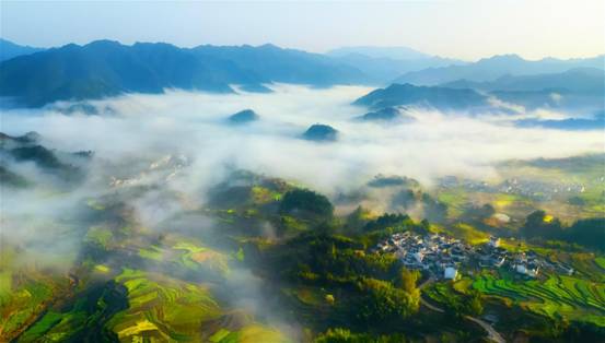 千村织锦连云起 万山叠翠日边来日出东方,一派辉煌,云涛绵延,峰峦叠嶂。大地阡陌交横、绿意盎然,犹如一匹巨型锦缎,数座古村点映其间,黑瓦白墙、玲珑有致,像无数花朵在大地上盛放。_meitu_1